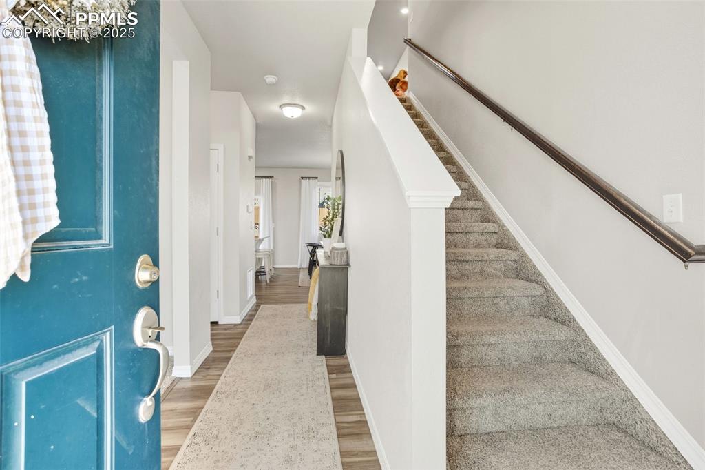 Entryway with light wood finished floors and stairs