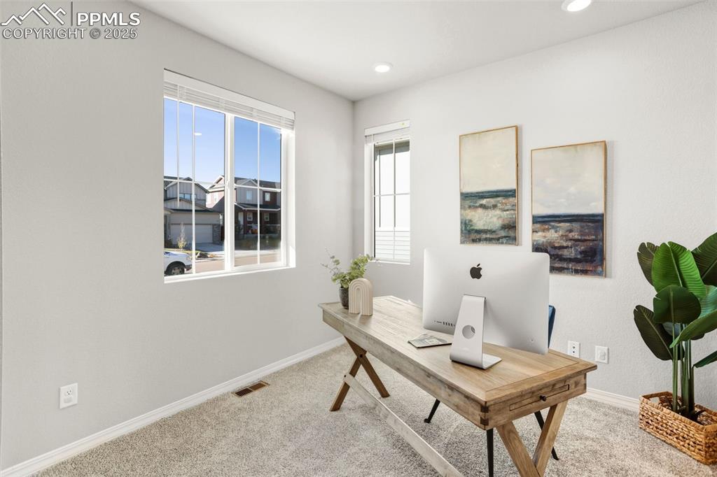 Office with light colored carpet and recessed lighting