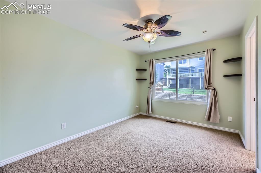 Carpeted ensuite bedroom with ceiling fan and baseboards with connected Jack and Jill bath