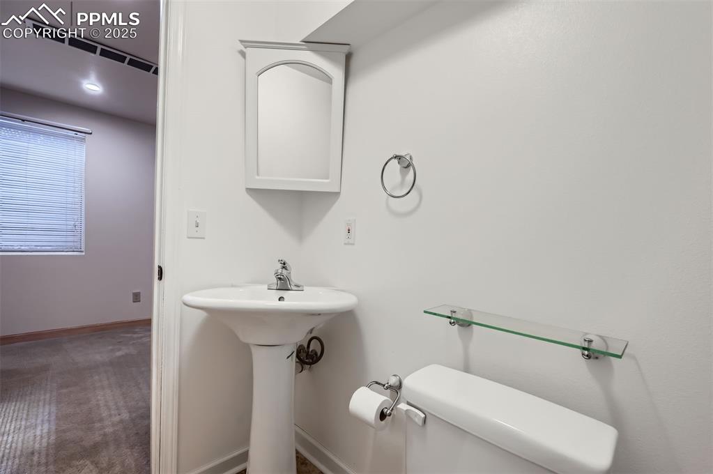 3/4 bathroom with toilet and baseboards