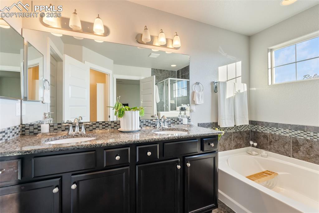 Five-piece primary bathroom with dual vanity and soaking tub.