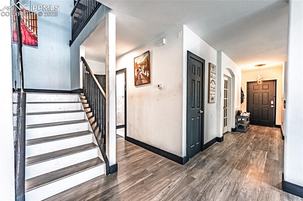 Stairway with wood finished floors and a textured ceiling
