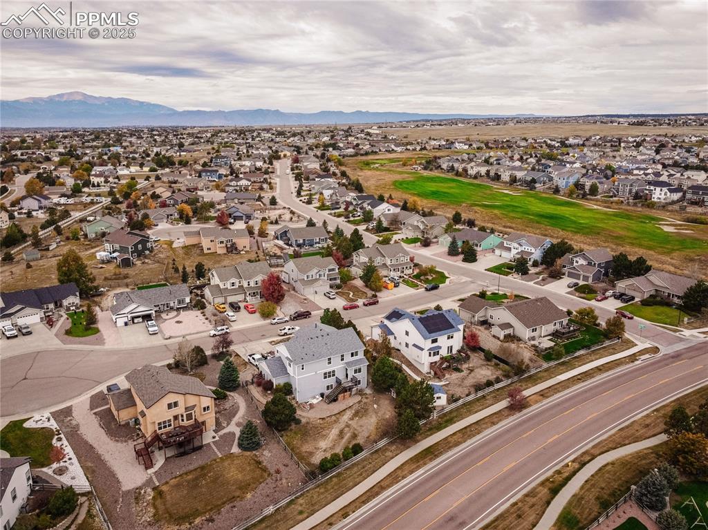 Aerial view of property's location featuring nearby suburban area and a mountainous background
