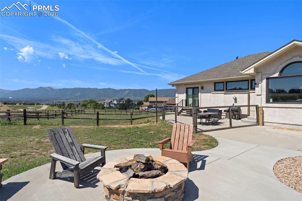 Fenced backyard with a mountain view and fire pit extra concrete patio and more