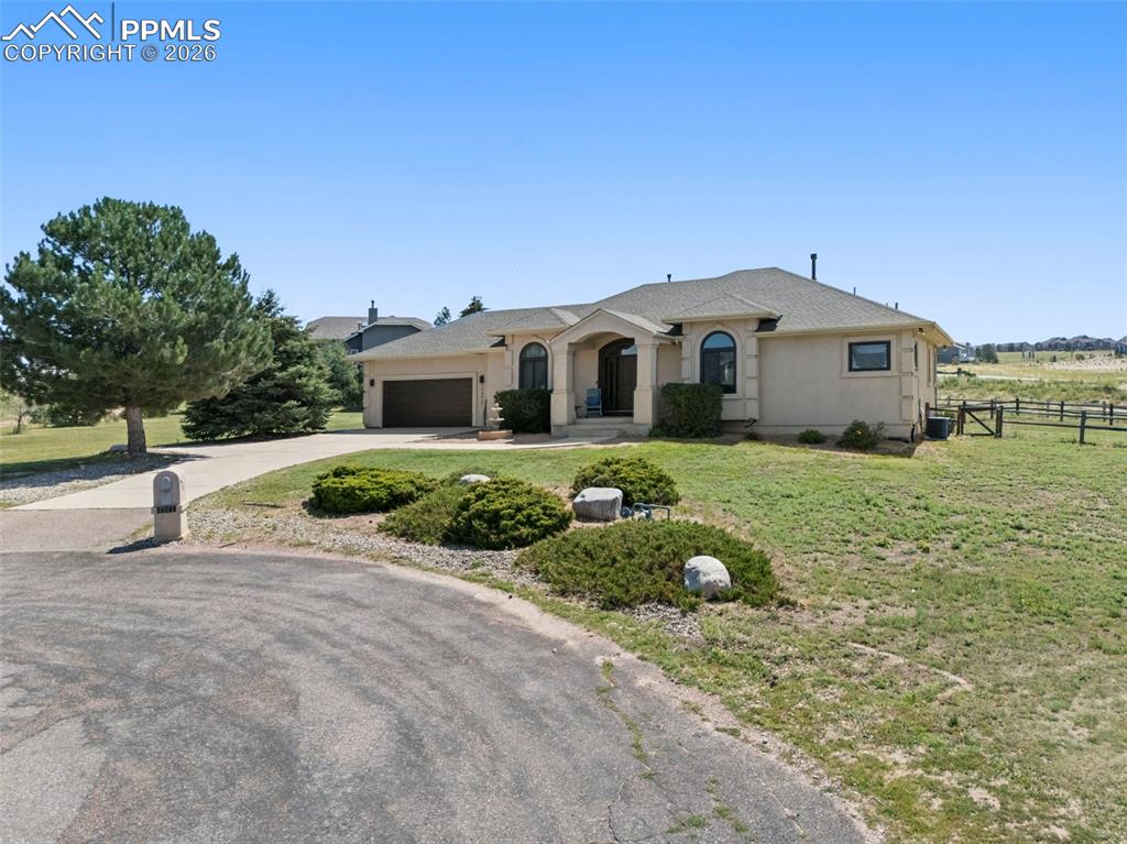End of cul-de-sac  front of property with concrete driveway, an attached garage, and stucco siding