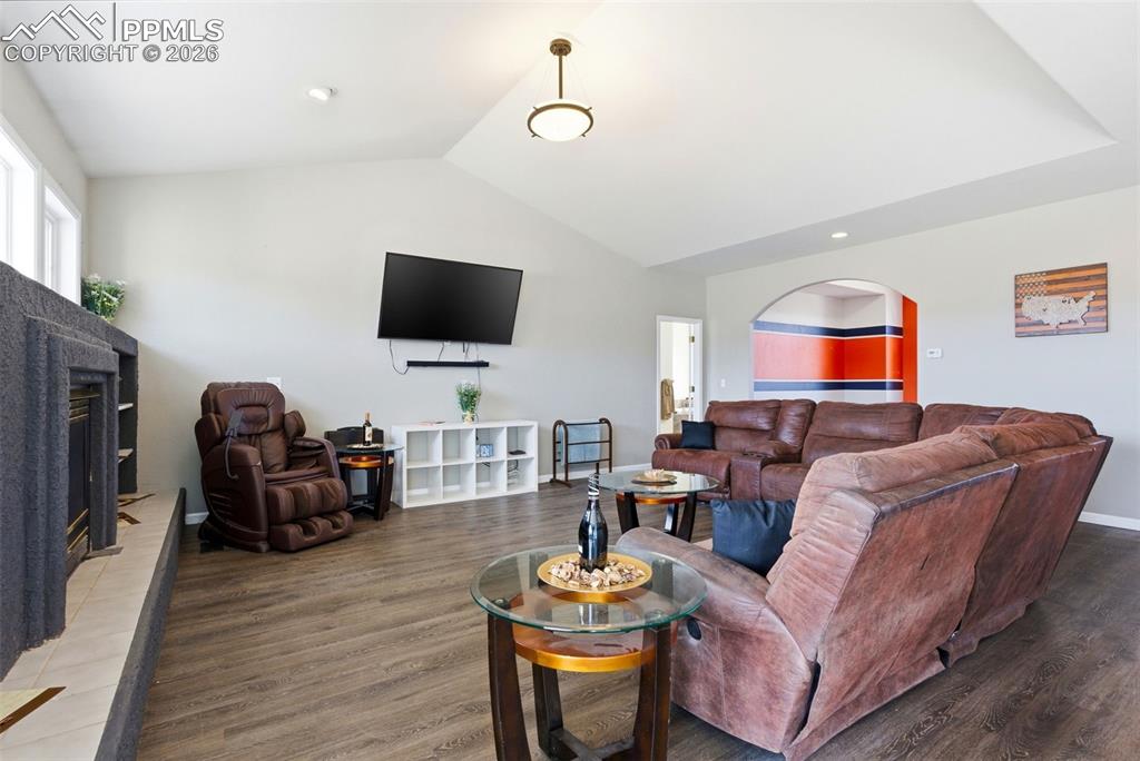 Living area featuring easy to clean floors, lofted ceiling, and a fireplace