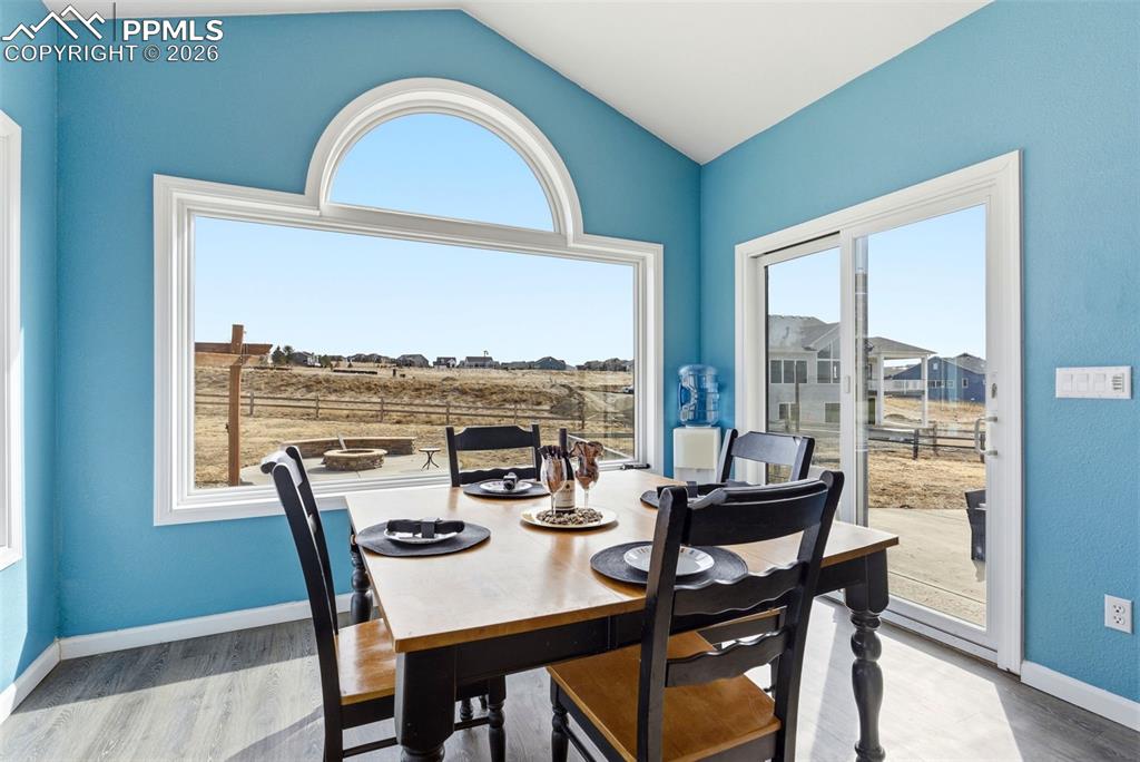 Dining room featuring vaulted ceiling and large windows