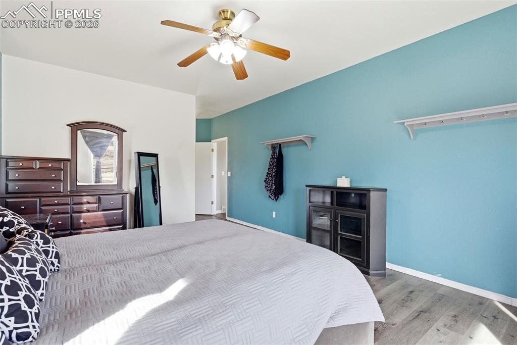 Master bedroom with light grey wood-style flooring