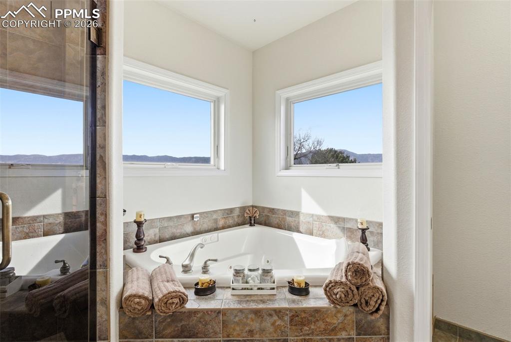 5 piece bath featuring a jetted tub and double vanity and separate shower