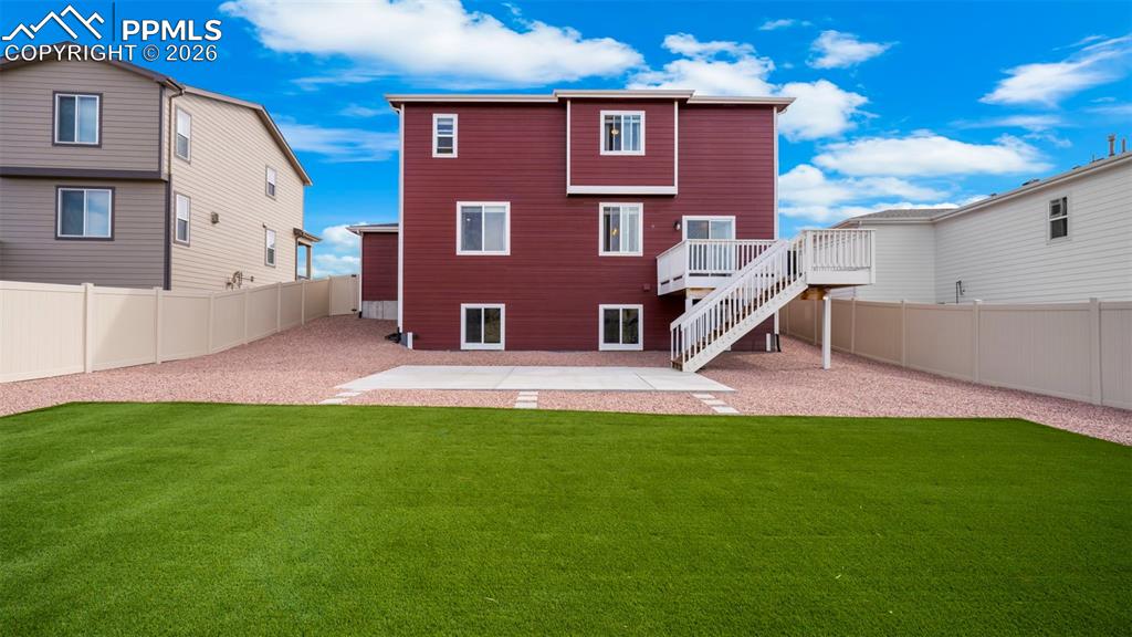 Back of house with a fenced backyard, a patio area, and a deck