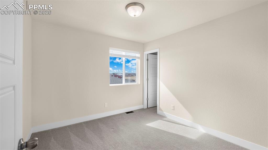 Unfurnished bedroom featuring light colored carpet and baseboards