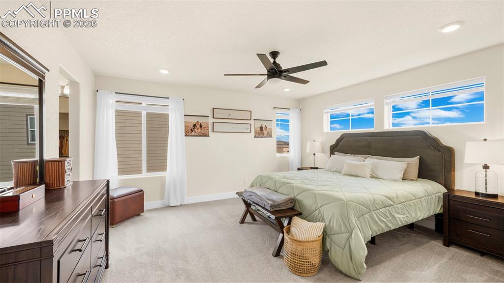Bedroom with light carpet, ceiling fan, and recessed lighting