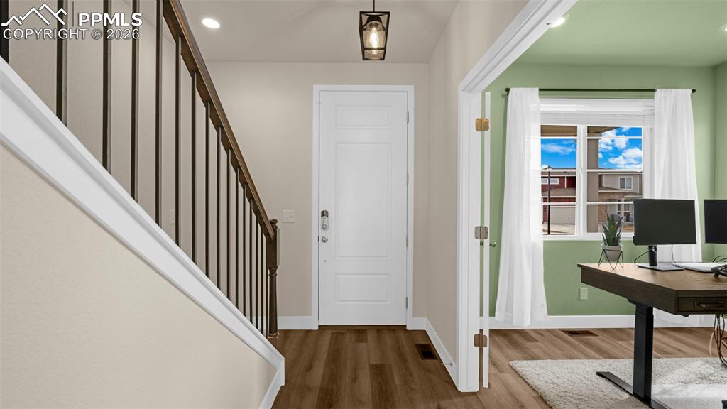 Foyer with wood finished floors and recessed lighting
