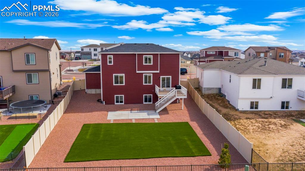 Rear view of property with a residential view, a fenced backyard, and a patio area