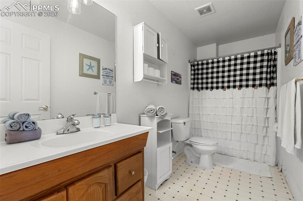 Bathroom featuring vanity, a shower with shower curtain, and light flooring