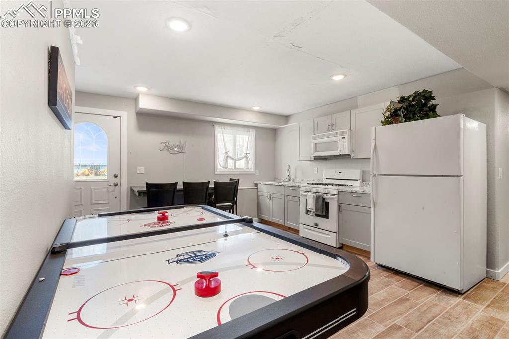 Game room with wood finish floors and recessed lighting