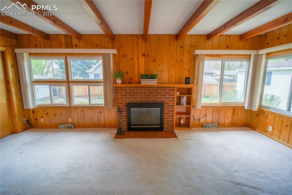 Wonderful knotty pine paneling, an abundance of natural light, and a brick fireplace makes this a special space indeed