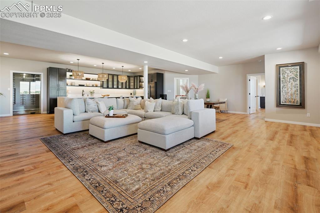 The centerpiece of the basement is this large gathering area with a sleek, fully loaded bar area behind it.