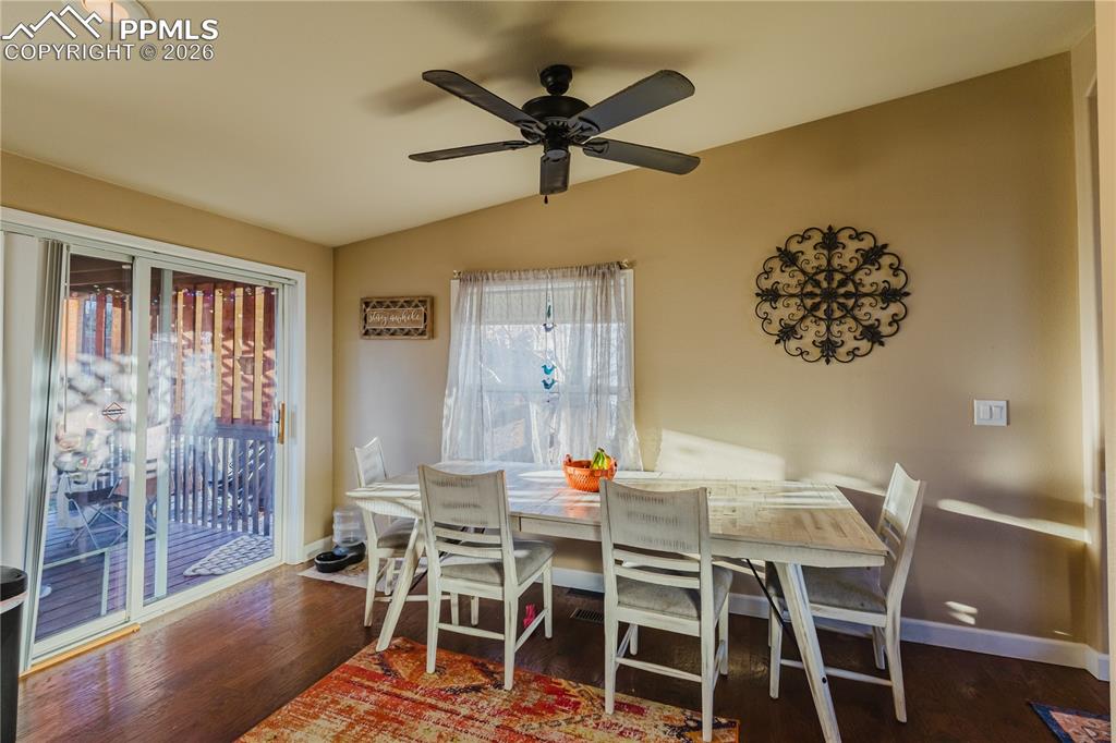 Dining room with lofted ceiling, dark wood-style flooring, and a ceiling fan