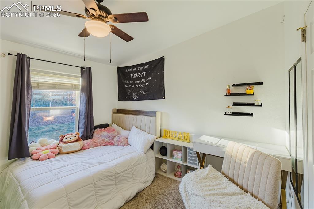 Bedroom with a ceiling fan and carpet floors