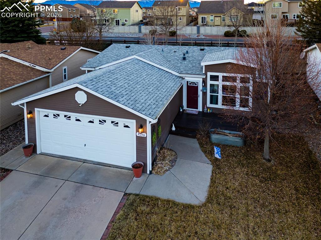 View of front facade with a residential view, driveway, and a garage