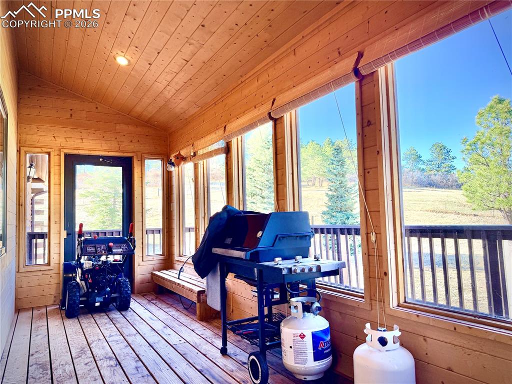 Sunroom featuring wooden walls, a vaulted wood ceiling, hardwood / wood-style flooring, and recessed lighting