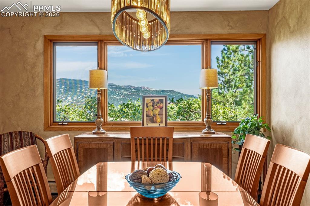 Dining room with a textured wall, a mountain view, and suspended lighting
