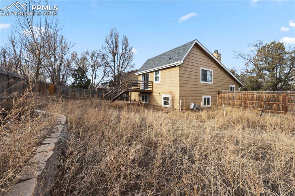 Rear view of home and fenced backyard.