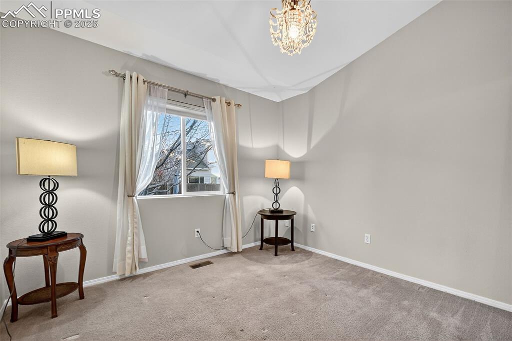 Second bedroom on main level, opposite side of home from the Primary! Vaulted Ceiling with nice Chandelier!