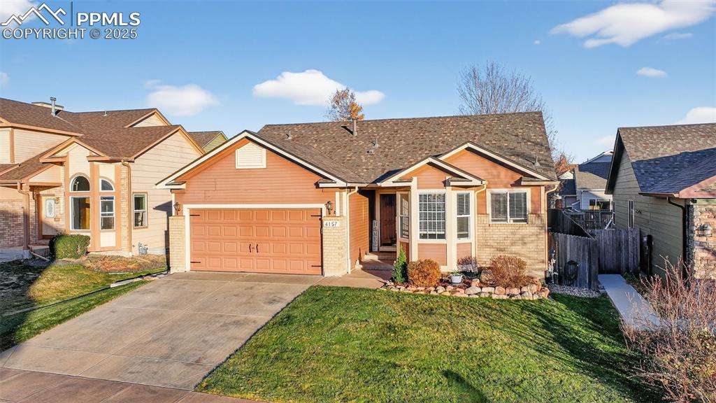 View of front facade featuring brick siding, concrete driveway, and an attached garage