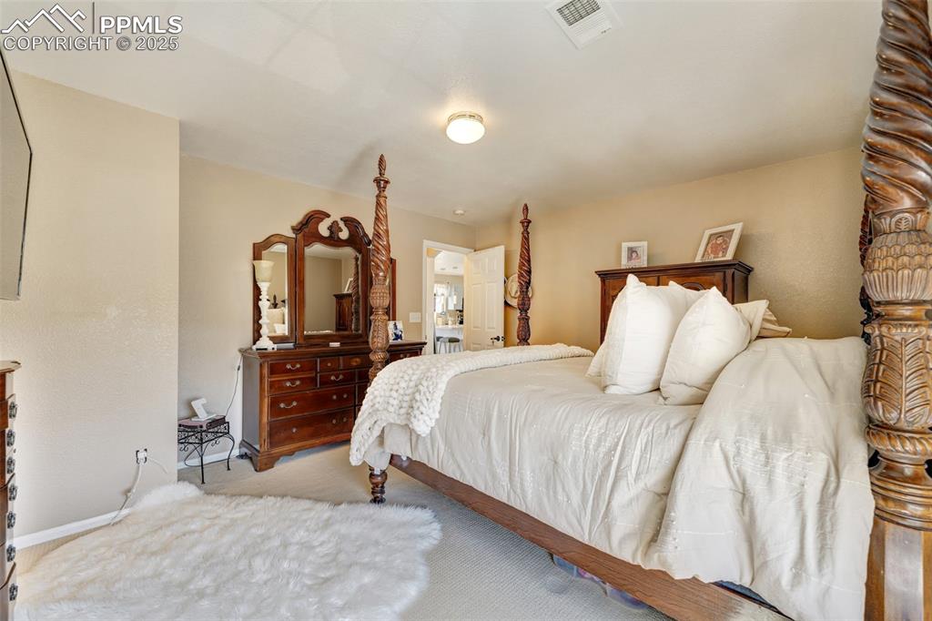 Bedroom with baseboards, carpet, and visible vents
