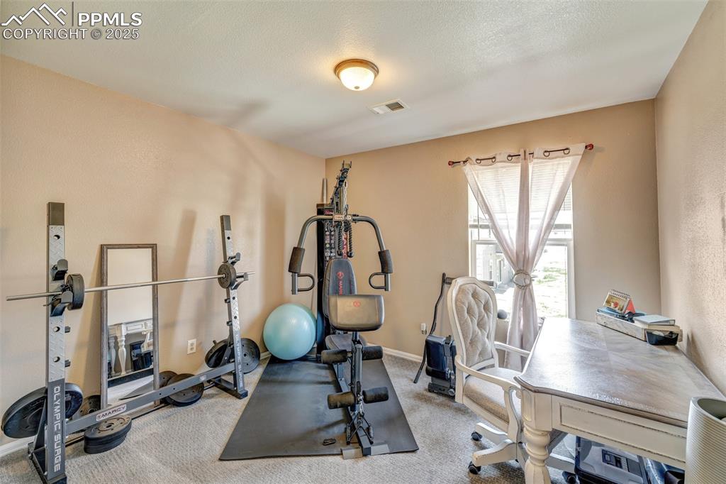 Workout room with baseboards, visible vents, and carpet floors