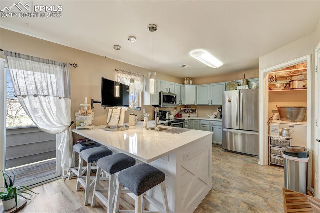 Kitchen featuring a wealth of natural light, a peninsula, a sink, and appliances with stainless steel finishes