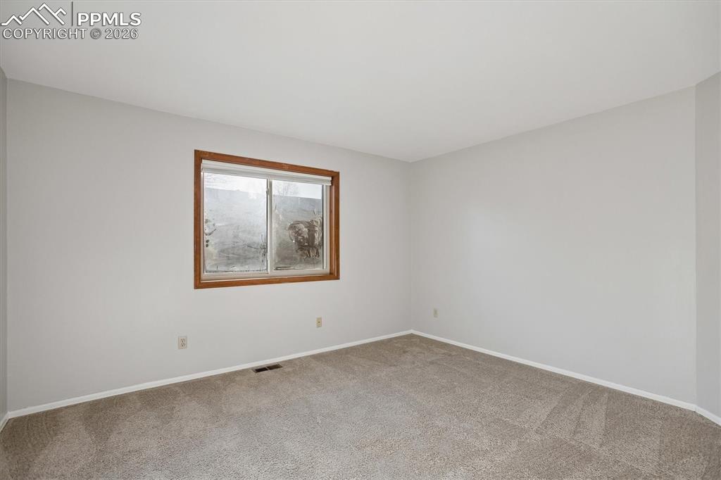 Carpeted empty room featuring baseboards