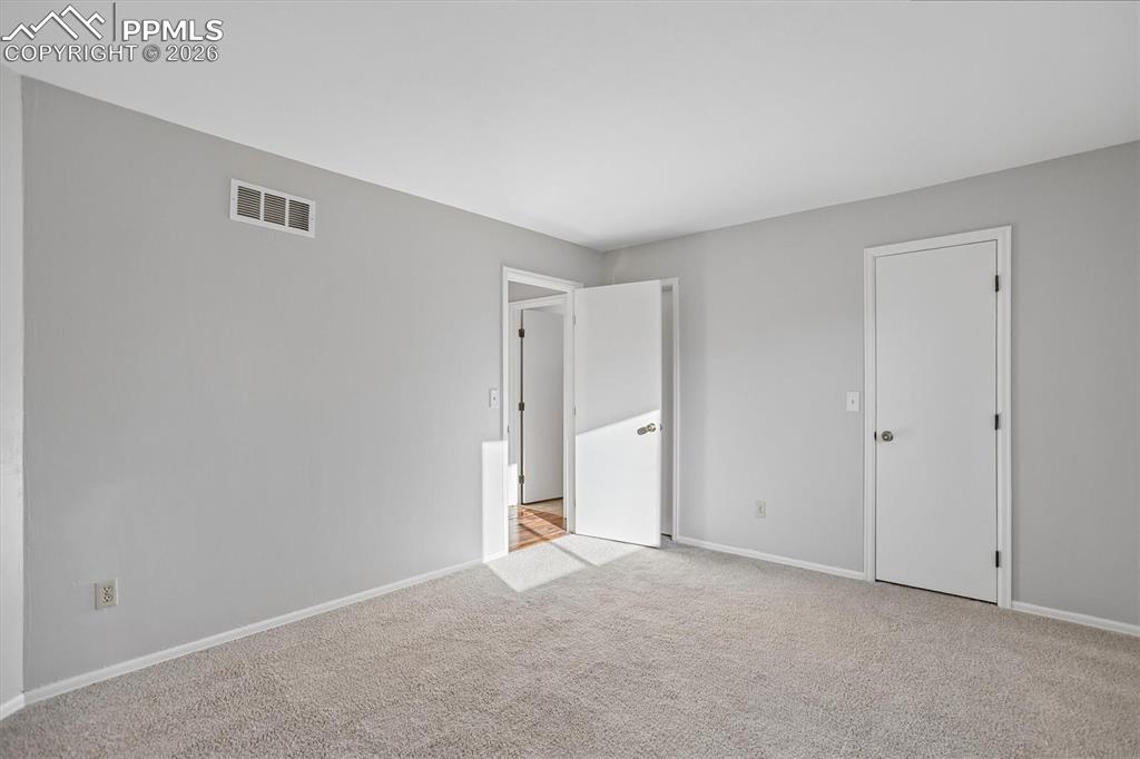 Unfurnished bedroom featuring baseboards and light carpet