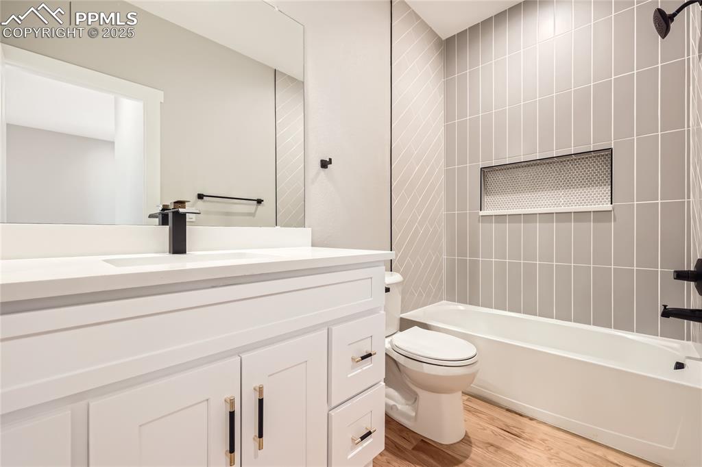 The main hall bath features a large vanity, quartz countertop, custom tile, and specialty lighting!