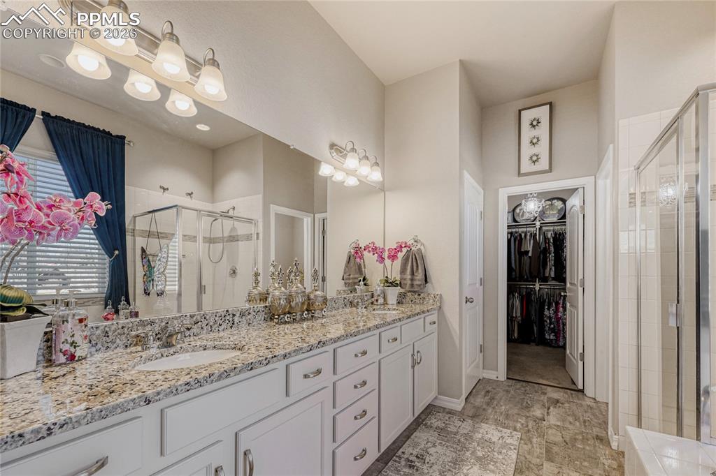 Master Ensuite featuring a shower stall, double vanity, and a walk in closet