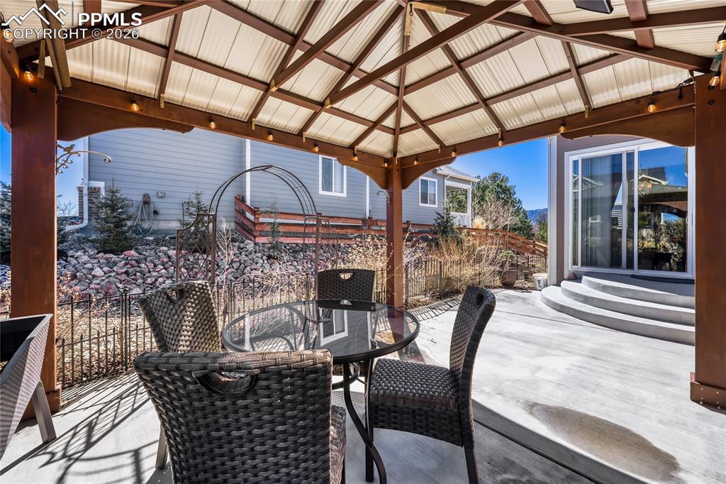 Wooden deck with a patio area, outdoor dining area, and a gazebo