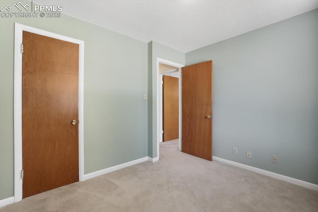 Unfurnished bedroom featuring carpet floors and baseboards
