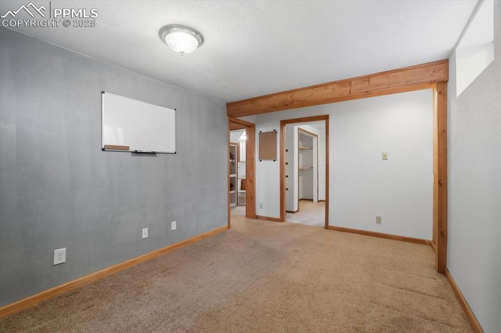Empty room with carpet floors and a textured ceiling