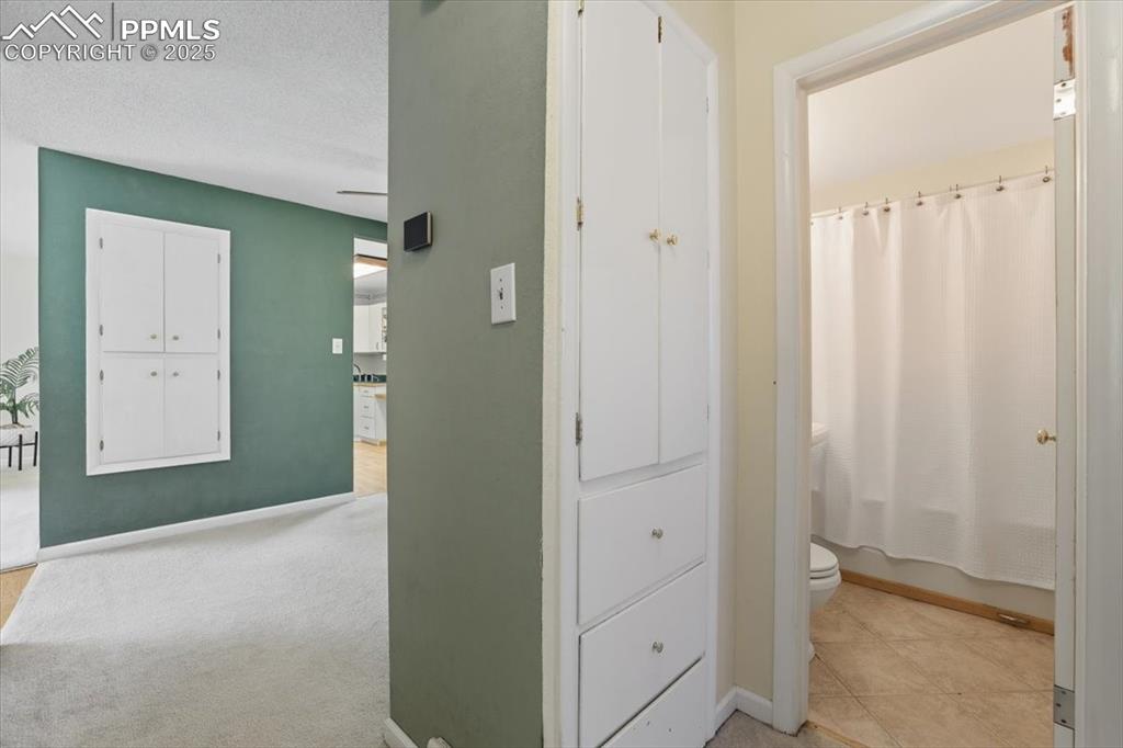 Hall featuring a textured ceiling and baseboards