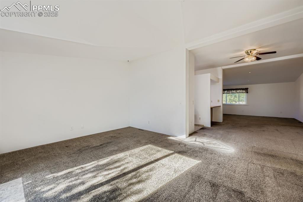 Carpeted spare room with ceiling fan