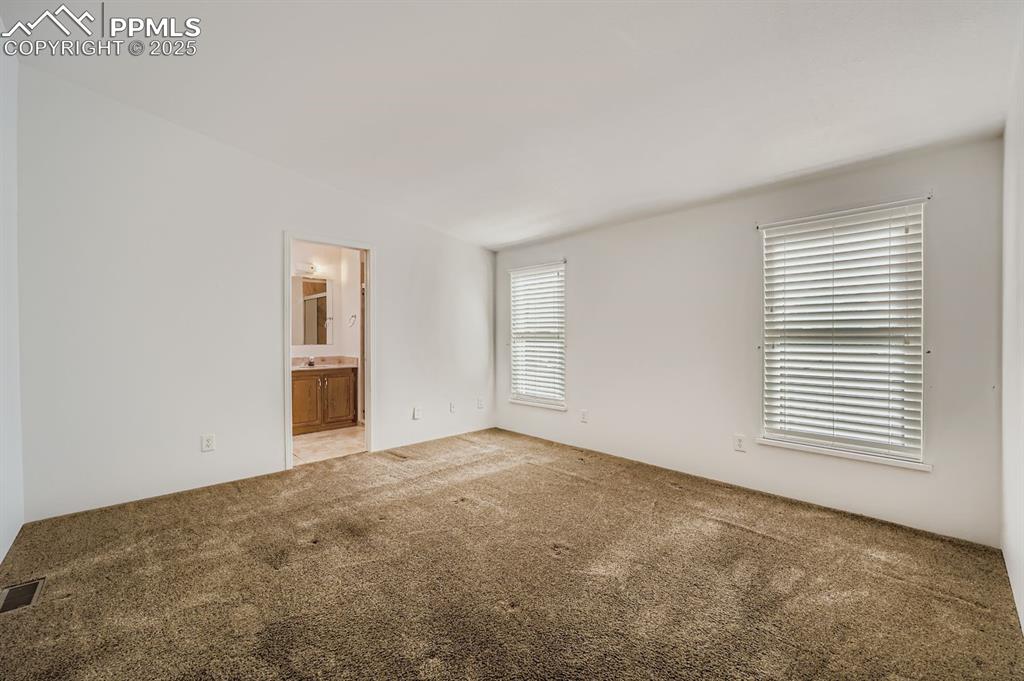 Unfurnished bedroom with carpet and ensuite bath