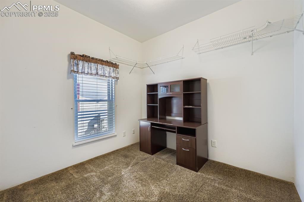 Unfurnished office with dark colored carpet