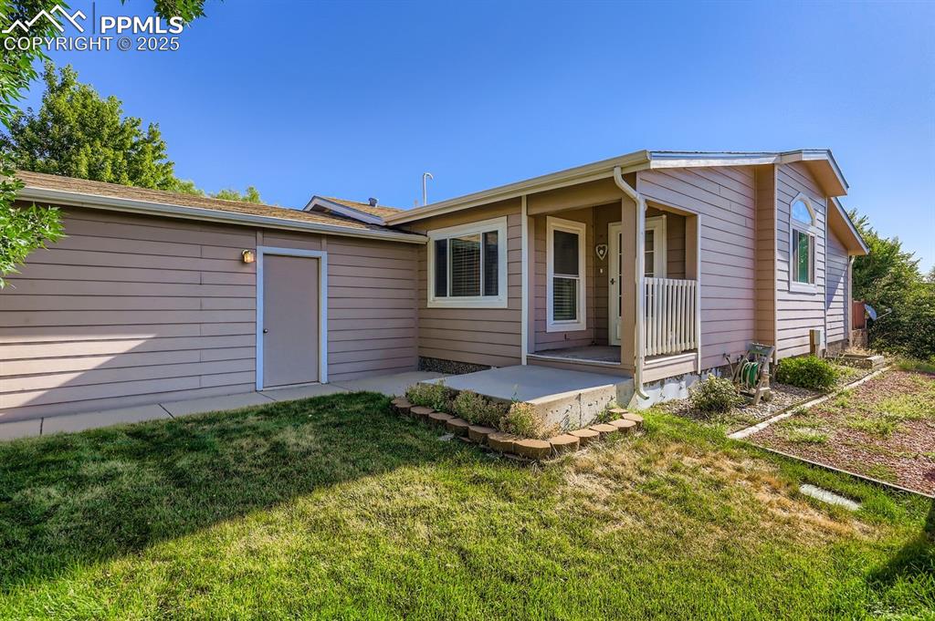 Back of house featuring a yard and a porch