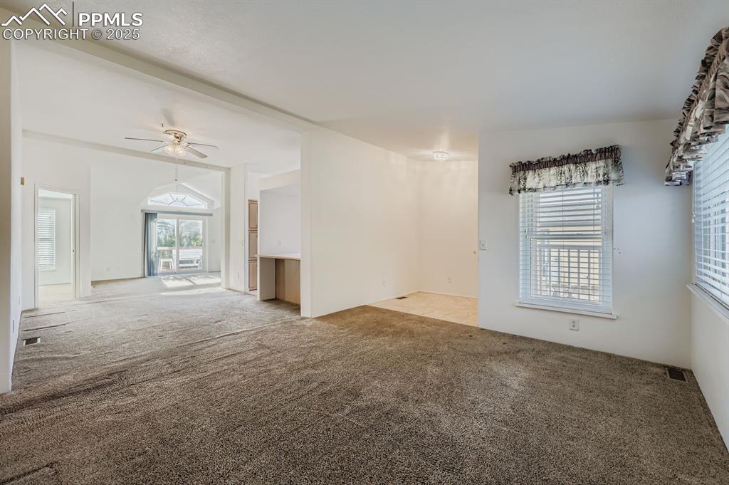 Carpeted empty room featuring ceiling fan