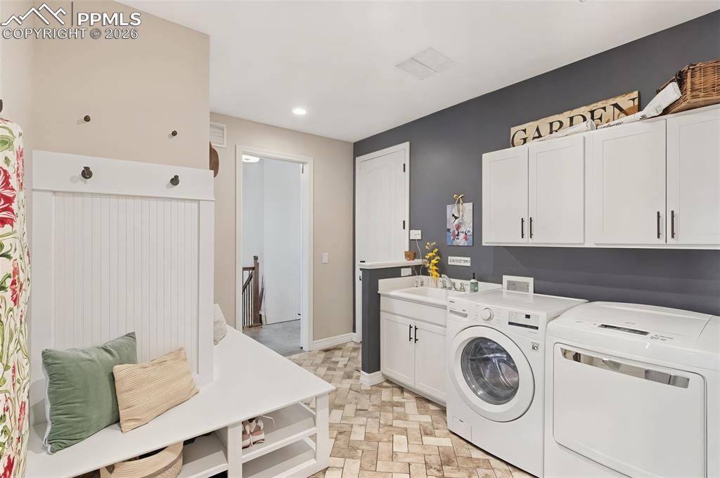 Function meets luxury in the expansive mudroom and laundry center, offering built-in drop-zone seating and utility space perfectly positioned to catch outdoor gear before entering the main living areas
