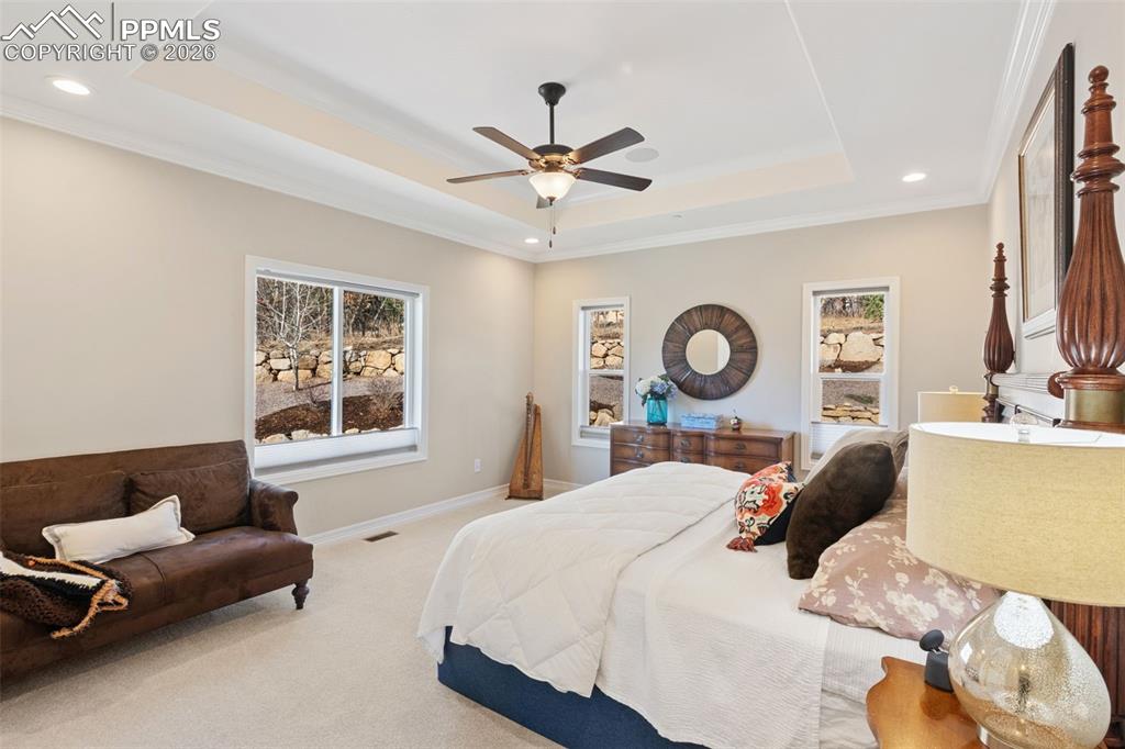 The primary suite is a true private retreat featuring an elegant tray ceiling and room for a seating area.
