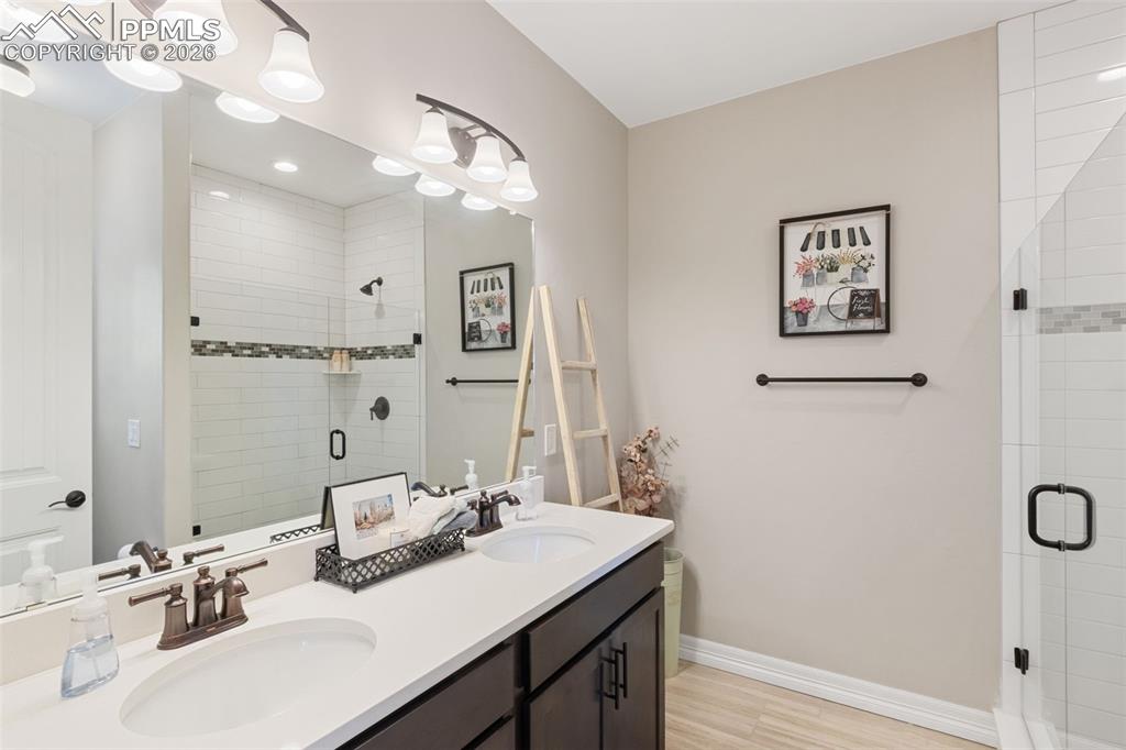 The bathroom offers a dual vanity and a walk-in glass shower that rivals most primary suites in scale and finish

