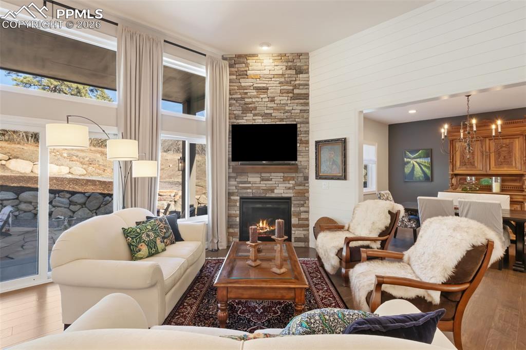 The primary living area is anchored by a floor-to-ceiling stone fireplace, creating a warm, centralized gathering space that flows effortlessly into the formal dining room
